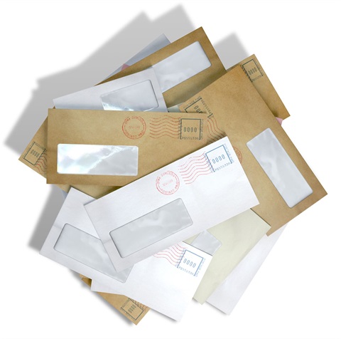 A pile of mixed paper including junk mail and envelopes