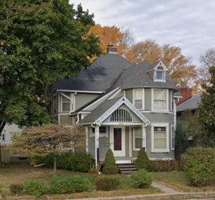A green house surrounded by landscaping