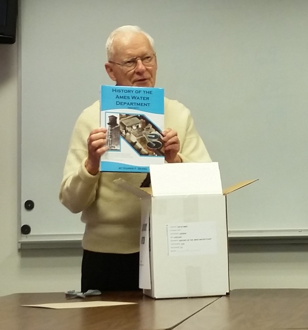 Harris Seidel holding the book History of Ames Water. 