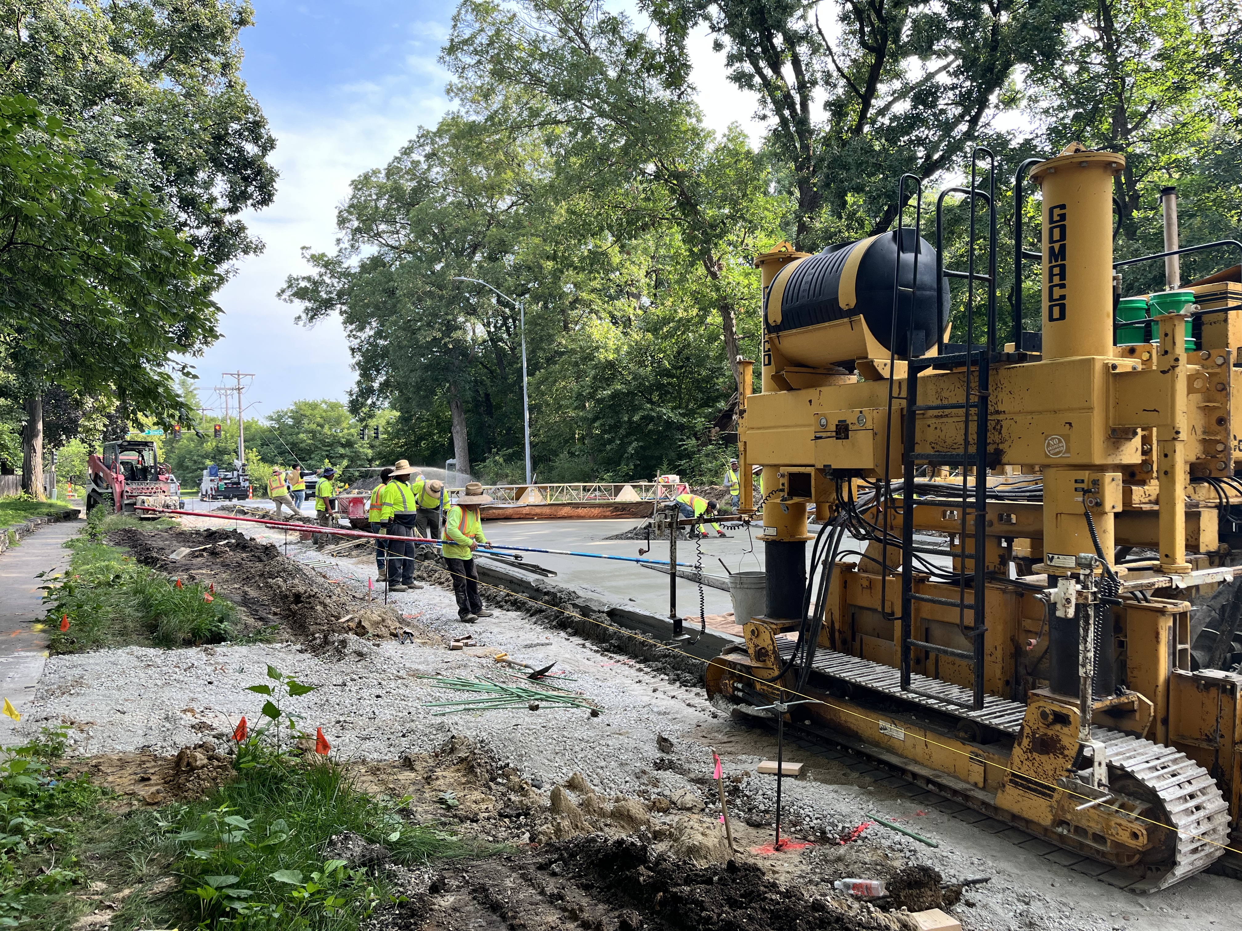 Street with paving equipment and people working to repave the street
